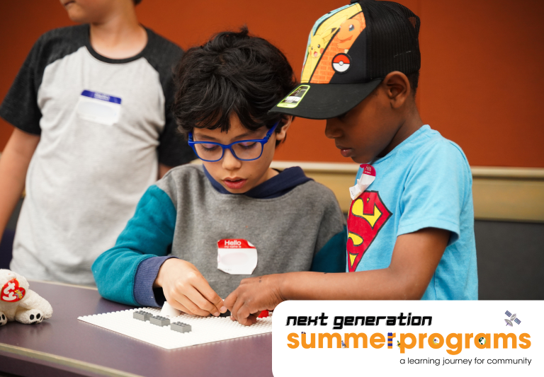 Two summer camper engaging with LEGOS in LEGO robotics.