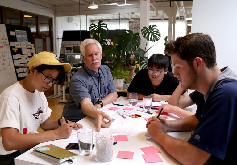 Students studying with instructor at Saturday Academy