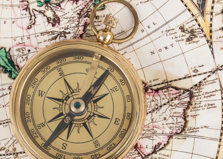 Traveling the World An antique compass on a map, illustrating world travel.