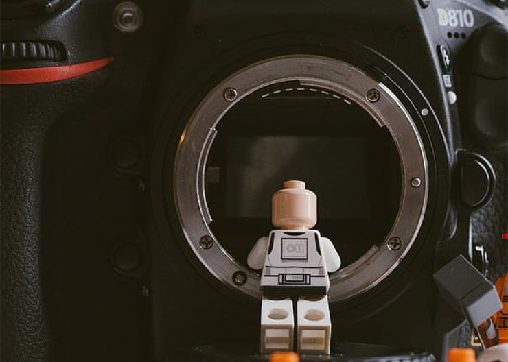 Lego figure looking into a dslr camera.