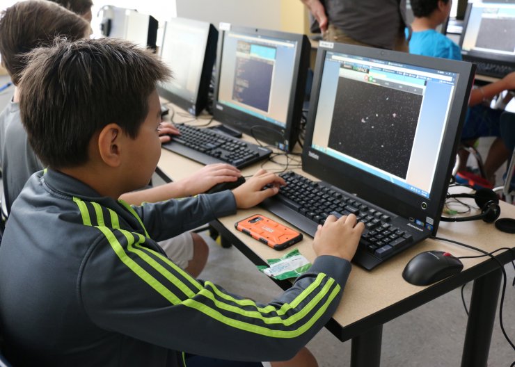 Two students work at computers in Saturday Academy’s Programming in Python summer camp