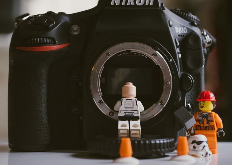 Two LEGO people are examining the lens of a DSLR camera - just an example of what students could create in this Saturday Academy LEGO class!
