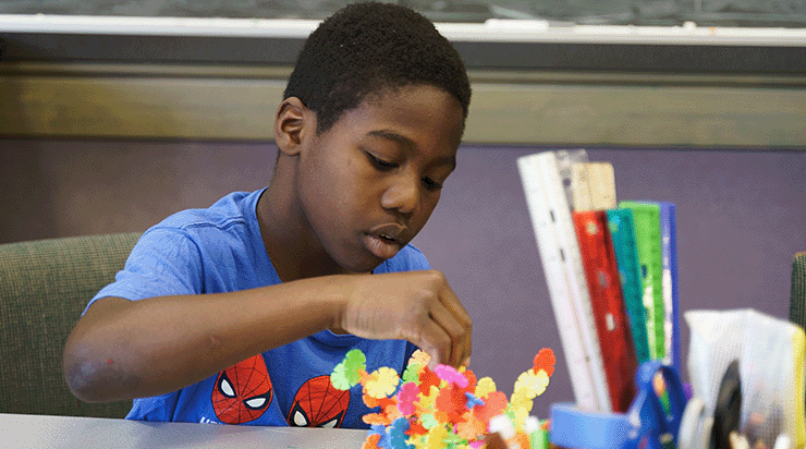 Kid engaging with puzzle activity in a STEAM class.