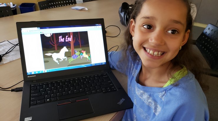 Saturday Academy student proud displaying her computer project with unicorn