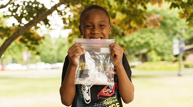 K-2 summer camp student holding up their pieces of an opened geode.