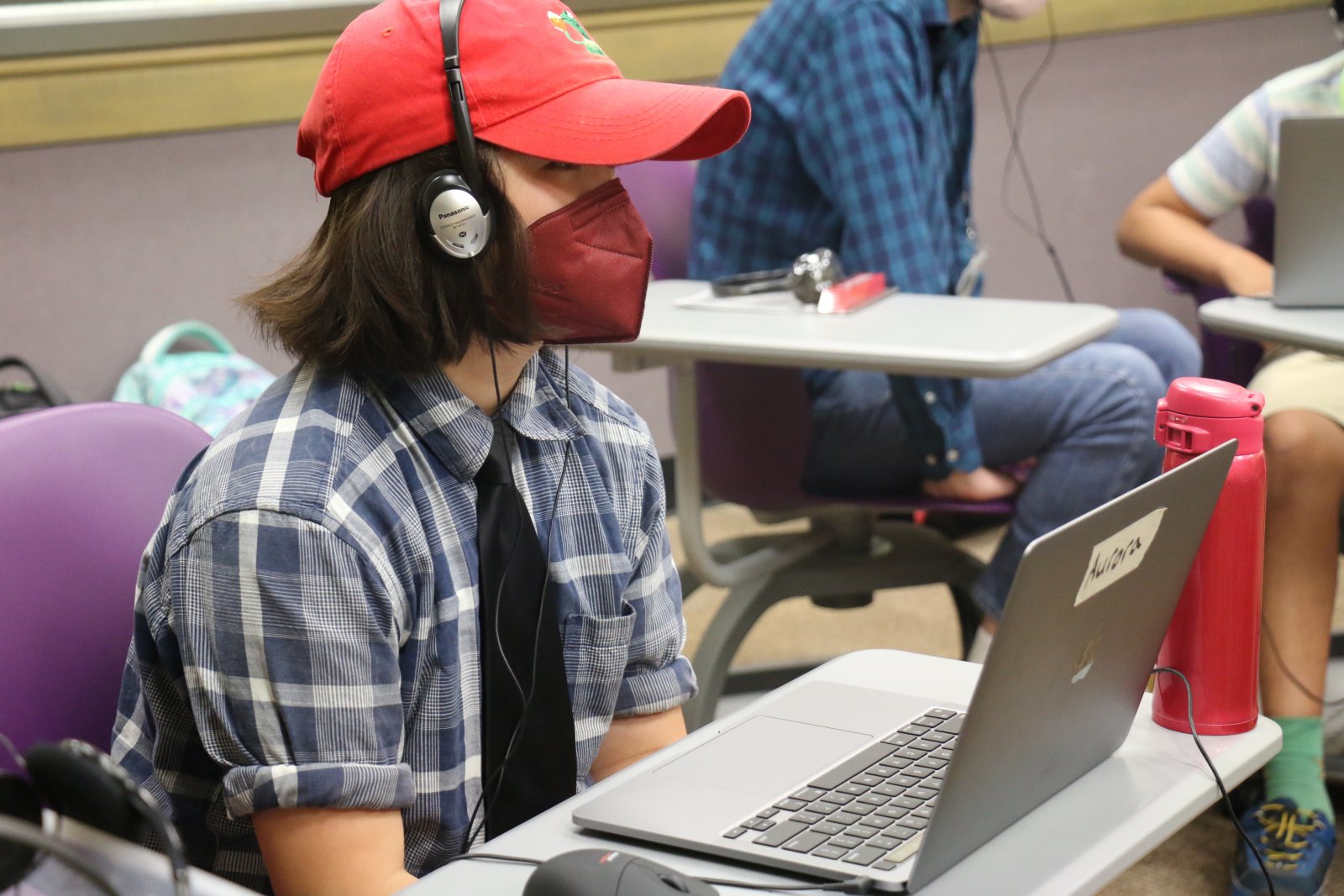 A student with headphones on in front of a laptop in Saturday Academy’s Electronic Music summer camp 