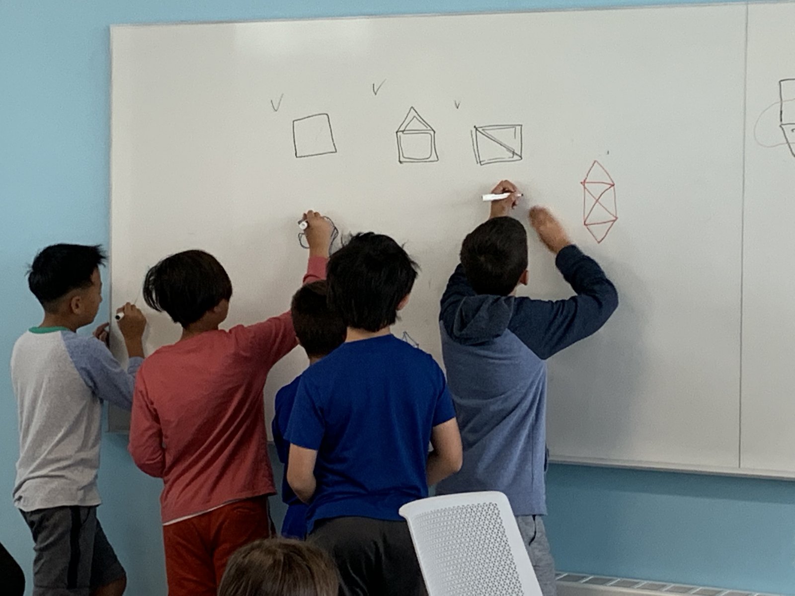 Saturday Academy students working on math problems on a white board