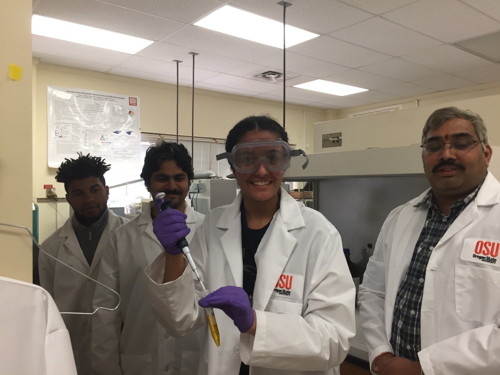 ASE interns in lab coats smiling for the camera